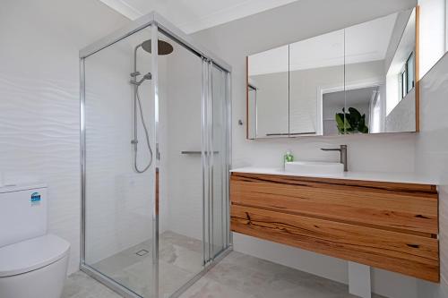 a bathroom with a shower and a toilet and a sink at Zilzie Beach House in Zilzie
