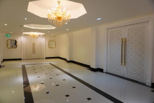 a large room with a chandelier and a door at Taris Art Hotel Phrae in Phrae