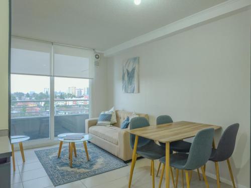 a living room with a table and a couch at Apart Total Aldunate Temuco Centro 2 in Temuco