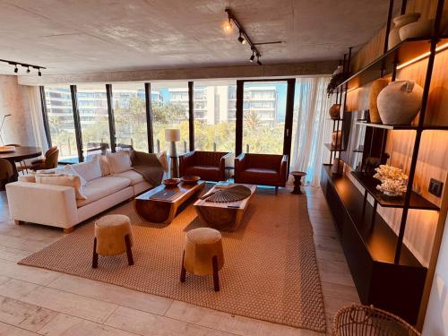 a living room with a white couch and chairs at Surfside - 3 Suítes - 4 Bathroom in Punta del Este