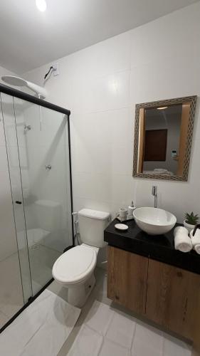 a bathroom with a toilet and a sink and a mirror at Atins Brisa in Barreirinhas