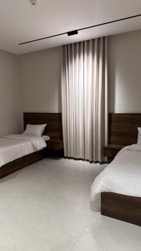 a bedroom with two beds and a window at Rose House 2 in Taif