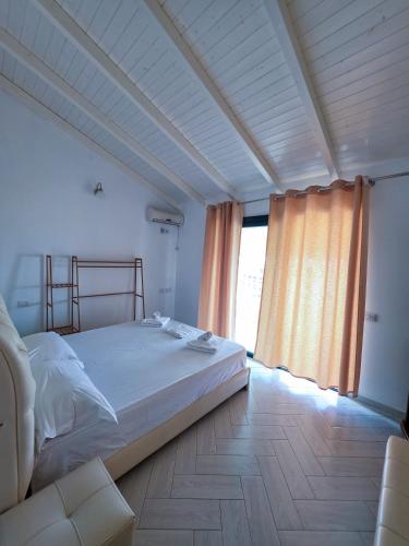a bedroom with a bed and a large window at Sunrise Dhermi Beach in Dhërmi