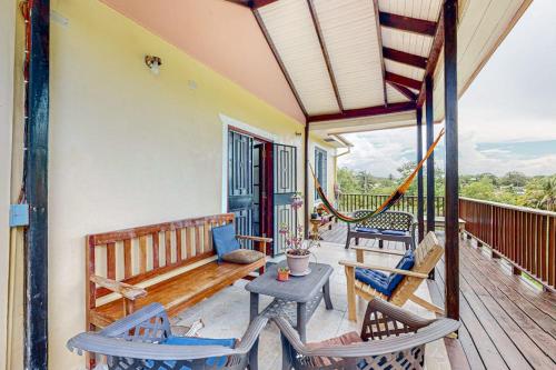 a porch with chairs and a table and a hammock at The Pine Tree Villa in San Ignacio