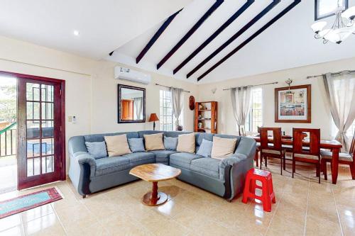 a living room with a blue couch and a table at The Pine Tree Villa in San Ignacio