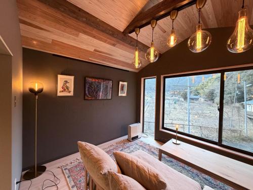 a living room with a couch and a table at KUMANOYASAI Cottage in Chikatsuyu in Tanabe