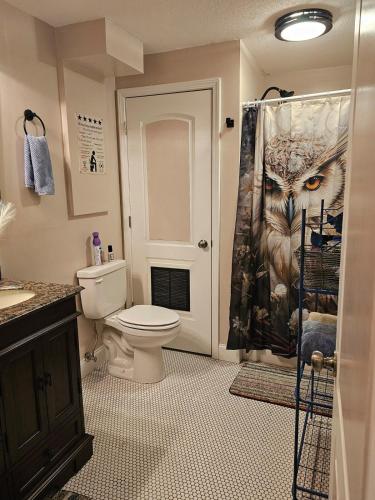 a bathroom with a toilet and an owl shower curtain at Rowan's Mountain View in Powell