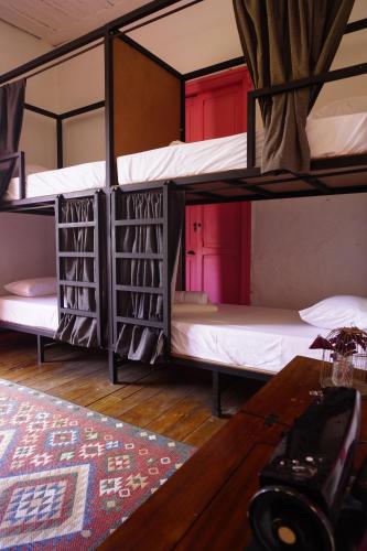 a room with two bunk beds and a desk at La Casa Rosada Hostel in Jericó