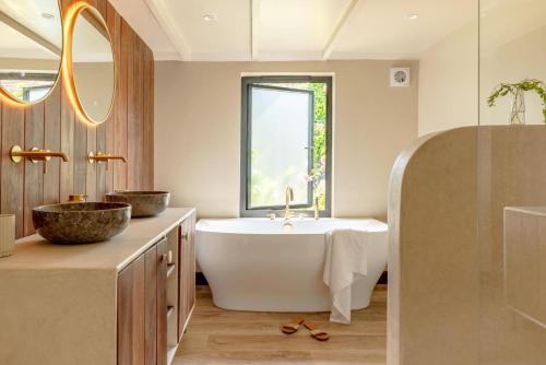 a bathroom with a tub and a sink and a mirror at 3 Bed in Ditchingham oc-s42751 in Ditchingham