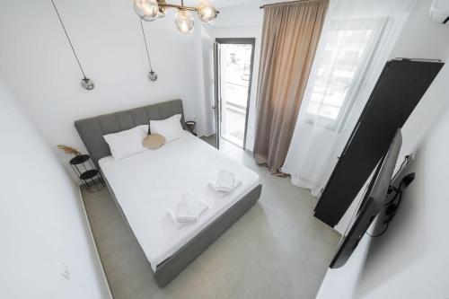 a bedroom with a white bed and a mirror at Ambra Luxury Suite 18 in Kallithea Halkidikis