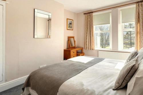 a bedroom with a bed and two windows at 3 Bed in Bassenthwaite oc-lr197 in Bassenthwaite