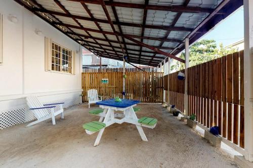 a patio with a table and chairs and a fence at Rainforest Suite at Casa DV Suites -Gold Standard Certified in Caye Caulker
