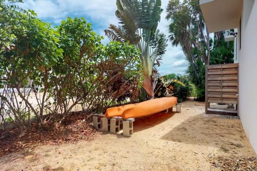 an orange boat sitting on the sand on a beach at Green Tower House in Placencia