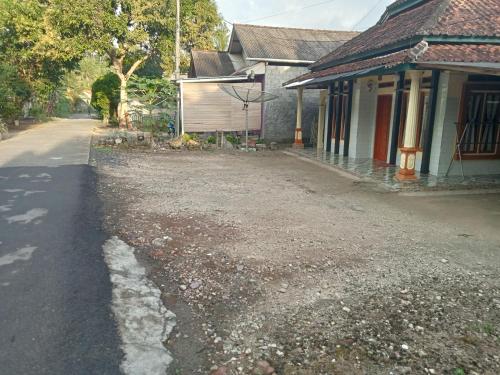 an empty street next to a house and a building at Jupe Homestay batukaras in Batukaras