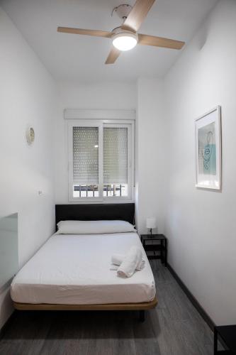 a bedroom with a bed and a ceiling fan at Metropolitano Guesthouse in Madrid