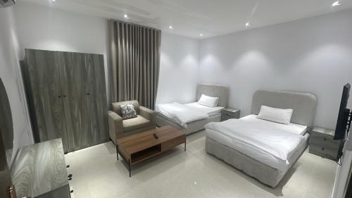 a bedroom with a bed and a chair and a desk at أرياف سويت in Al Baha