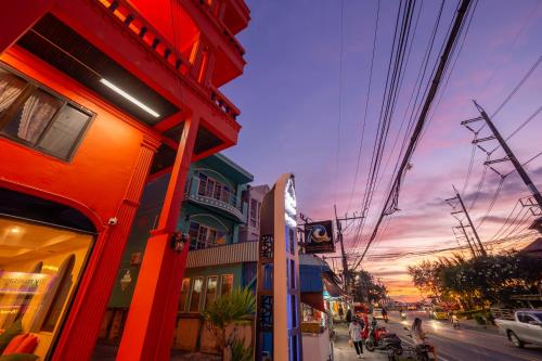 a group of buildings on a city street at sunset at Khaleej Mass Hotel Patong in Patong Beach