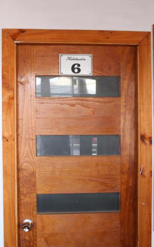 a wooden door with the number six on it at Residencial Victoria Said in Linares