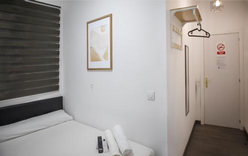 a small room with a bed and a bathroom at Metropolitano Guesthouse in Madrid