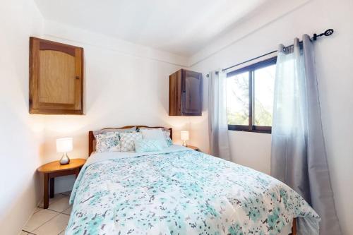 a bedroom with a bed and a window at Charming Suite with WiFi AC Shared Pool Grill Area & Rooftop Deck in Caye Caulker