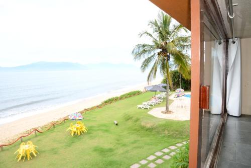 a view of a beach with umbrellas and the ocean at Brisa Hotel in Caraguatatuba