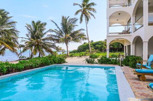 a swimming pool in front of a house with a beach at Relaxing condo with shared pool ocean views partial AC & WiFi in San Pedro