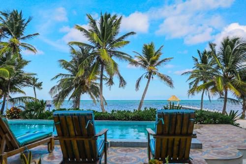 a resort pool with palm trees and the ocean at Relaxing condo with shared pool ocean views partial AC & WiFi in San Pedro