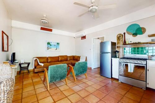 a living room with a couch and a kitchen at Charming beachfront condo with a kitchenette shared pool WiFi & beach access in Placencia
