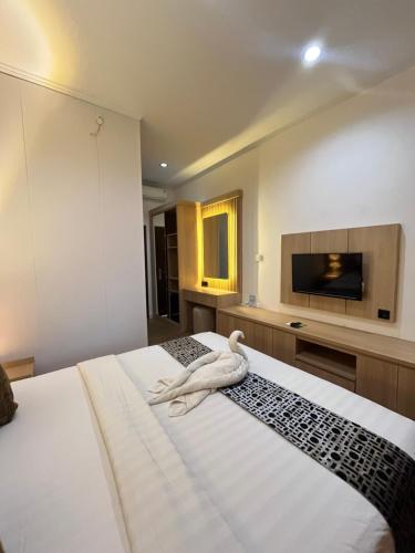 a bedroom with two beds with a white swan on it at Jesens Inn II in Kuta