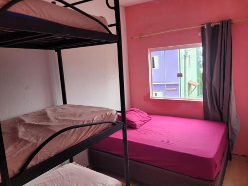 two bunk beds in a room with a window at mirante por do sol in São Thomé das Letras