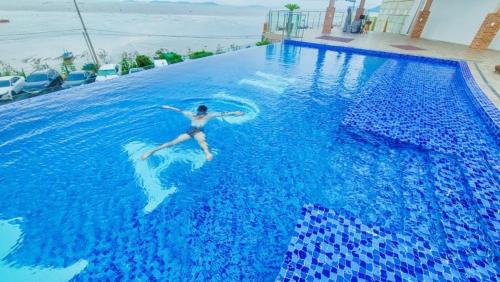 a person swimming in a large blue swimming pool at Raum Resort 1 in Suncheon