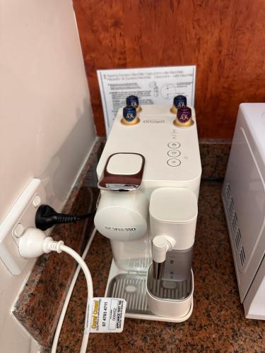 a coffee maker sitting on a counter next to a microwave at Ayr Traveller's Motel in Ayr