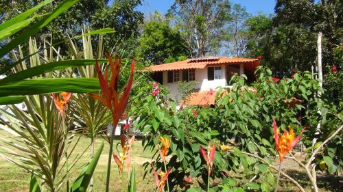 a house in the middle of a garden with flowers at Cebaco Sunrise Lodge in Isla Cebaco 