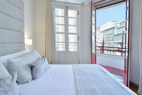 a bedroom with a large bed and a balcony at Hostal Zahara in Ferrol