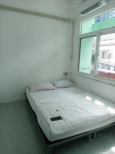 a bed in a room with a window at Urban Nest Hostel in Bangkok