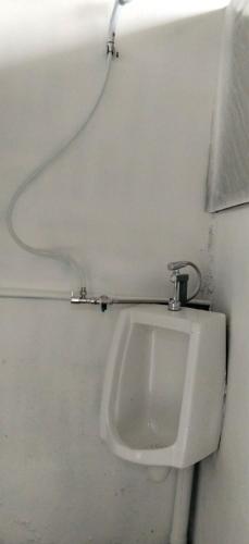 a bathroom with a urinal on a wall at Urban Nest Hostel in Bangkok