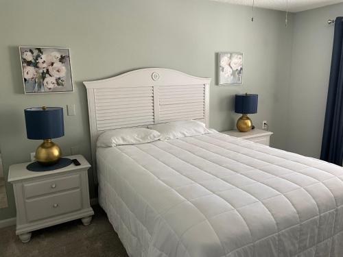 a bedroom with a large white bed with two lamps at Highland Estates Condotel in Mesquite