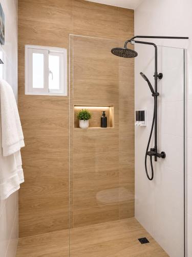 a shower with a glass door in a bathroom at HERGOZ Apartamentos in Cayetano Germosén