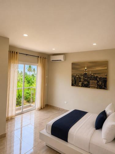 a bedroom with a large bed and a large window at HERGOZ Apartamentos in Cayetano Germosén