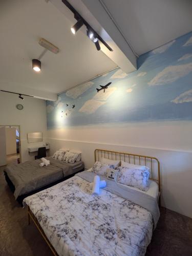 two beds in a room with a painting on the wall at AeroHomesuites Tawau in Tawau
