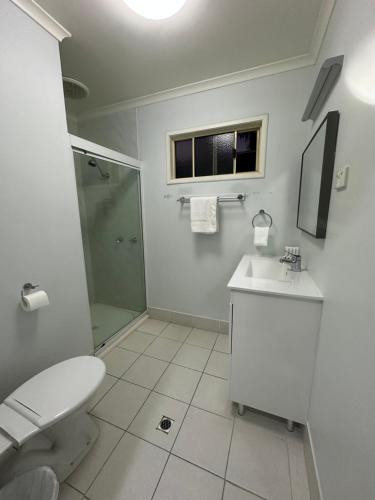 a bathroom with a toilet and a sink and a shower at Kookaburra Holiday Park in Cardwell