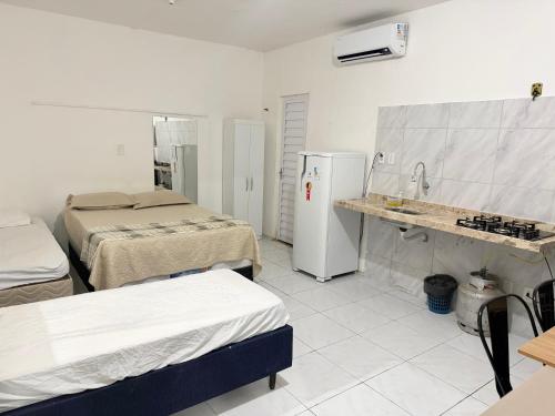 a hospital room with two beds and a refrigerator at Ap no Derby com garagem e ar in Sobral