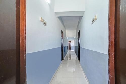 a hallway in a building with white walls at Hotel O SS in Chandrapur