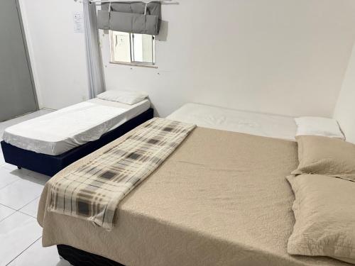 two twin beds in a room with a window at Ap no Derby com garagem e ar in Sobral