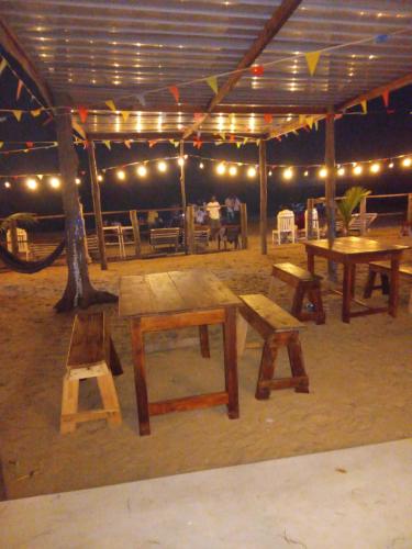 a group of picnic tables and benches in a tent at Beach Cab Resort in Arugam Bay
