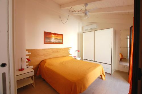 a bedroom with a bed with a yellow bedspread at Casa Vacanza "Donna Franca" in Castellammare del Golfo