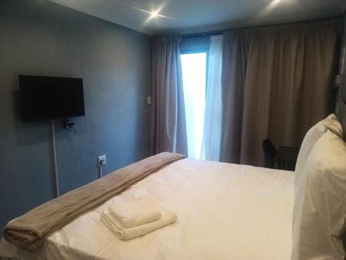 a hotel room with a bed with two towels on it at Lifeshed in Johannesburg