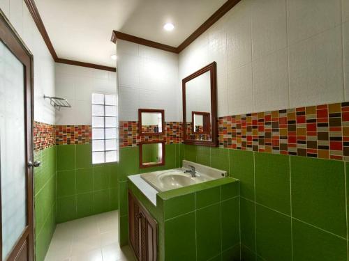 a green bathroom with a sink and a mirror at Fueangfu Pool Villa Chaweng in Chaweng