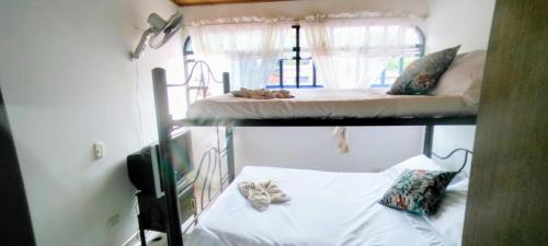 two bunk beds in a room with white sheets at Casa Vacacional Algarrobos in Girardot