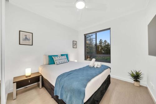a bedroom with a bed with a blue blanket and a window at Sub-Penthouse with Marina View by Host Solutions in Glenelg